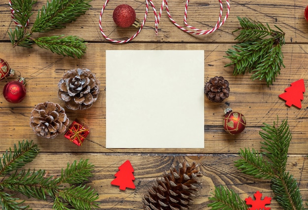 Winterkerstsamenstelling met een vierkante blanco kaart over houten tafel