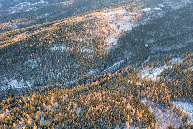 Winterlandschap in de bergen, foto vanaf een hoogte. Het winterbos in de bergen is bedekt met verse sneeuw. Vakantie in de bergen