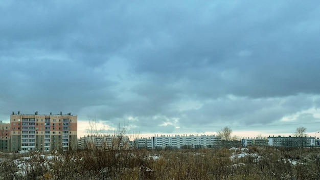 Winterlandschap in de voorsteden en woongebouwen onder een sombere bewolkte hemel