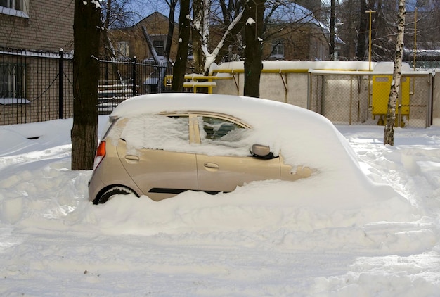 Winterlandschap met auto bedekt met sneeuw