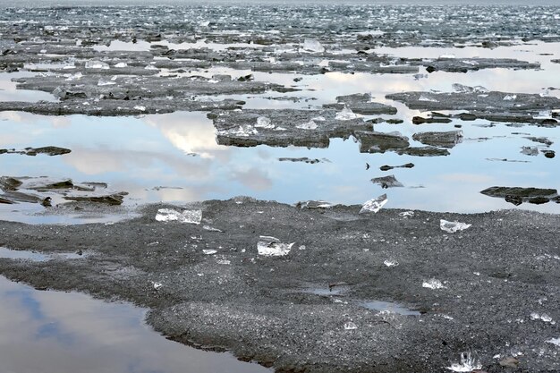 Winterlandschap met grijze smeltende dreigende gebroken ijsvlokken die in het rivierwater drijven