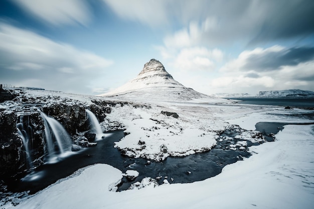 Winterlandschap met rijzende zon op de Kirkjufellsfoss-waterval en de Kirkjufell-berg IJsland Europa