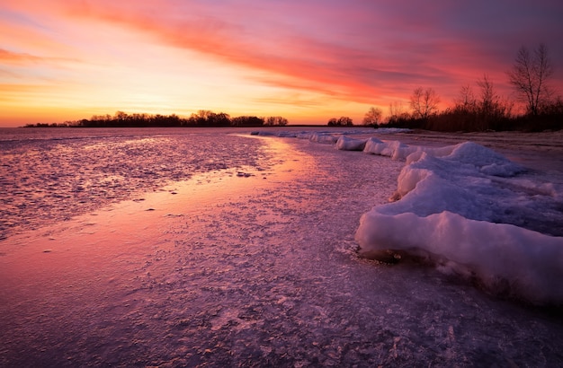 Winterlandschap met vurige zonsondergang hemel. Samenstelling van de natuur.