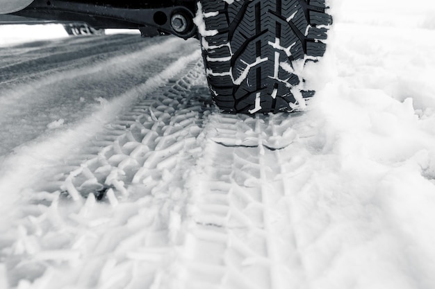 Winterlandschap met weg en zwarte auto