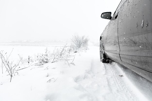 Winterlandschap met weg en zwarte auto