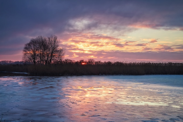 Winterlandschap met zon en rivier. Zonsopkomst.