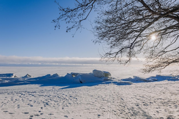 Winterlandschap Panoramisch uitzicht op een prachtige zonsondergang in de baai IJs sneeuw en rotsen aan de kust Zonondergang in helder licht