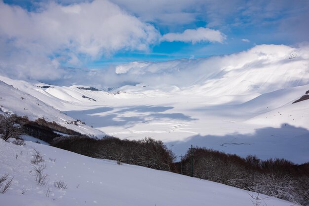 Winterlandschap vallei en heuvels bedekt met sneeuw op zonnige dag