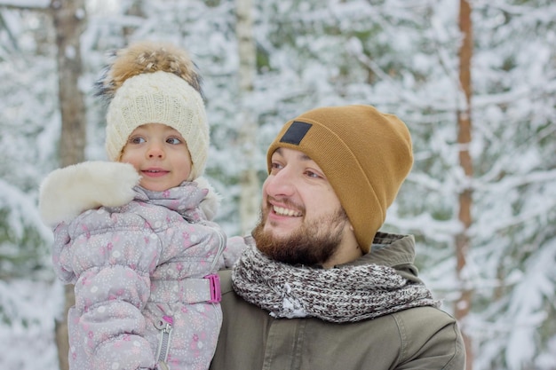 winterportret van jonge, bebaarde vader en zijn dochtertje buitenshuis