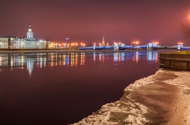 Winterroze ochtendlandschap van de neva in st. petersburg met uitzicht op de paleisbrug en de kunstkamera