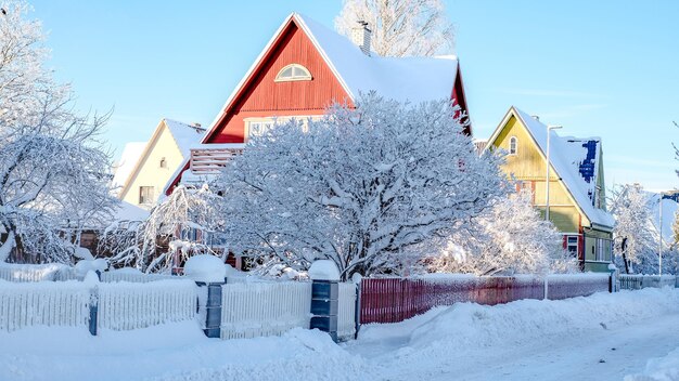 Wintersprookjeslandschap op straat met huisjes met een driehoekig dak en met veel sneeuw bedekte wegen