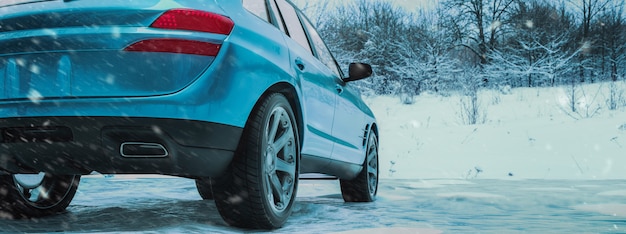 Wintertijd en auto in sneeuw.