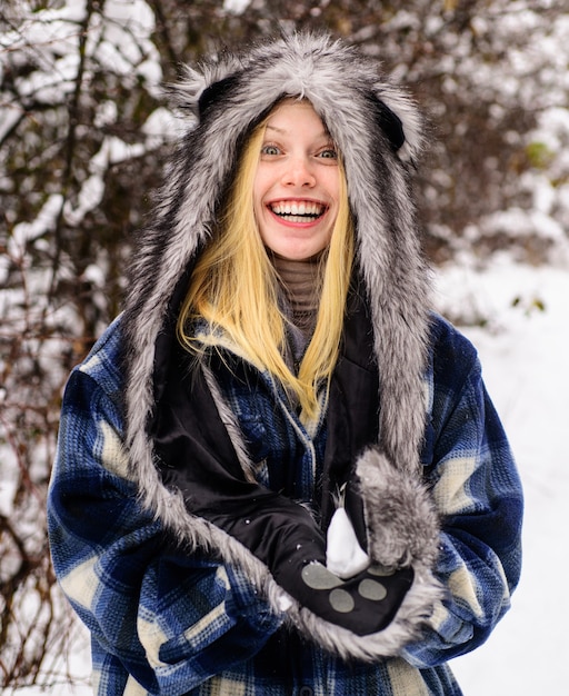 Wintertijd. Glimlachende vrouw in warme kleding met sneeuwbal. Meisje spelen met sneeuw. Seizoen van de winter.