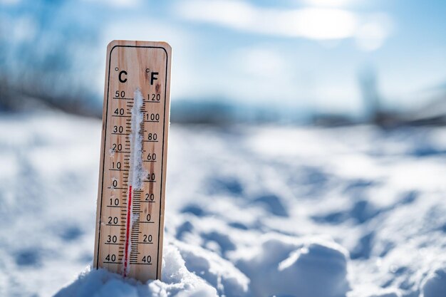 Foto wintertijd thermometer op sneeuw toont lage temperaturen in celsius