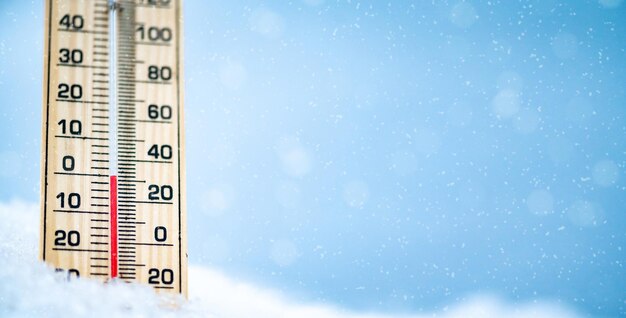 Wintertijdthermometer op sneeuw met wazige achtergrond toont lage temperaturen celsius en farenheit