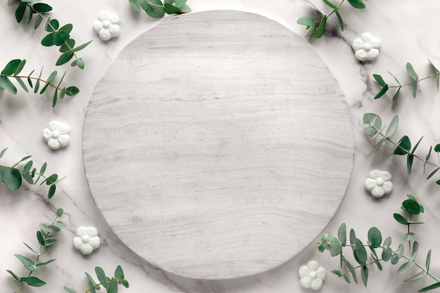 Wintertime mockup with copy-space on circle stone board. Fresh eucalyptus twigs on white marble.