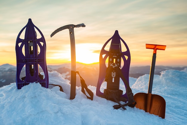 Winteruitrusting van een ijsklimmer de achtergrond van besneeuwde bergen