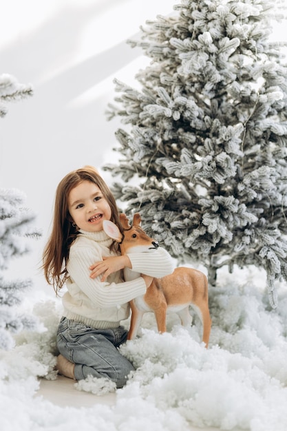 Wintervakantie en mensen concept gelukkig klein meisje in de buurt van de kerstboom thuis