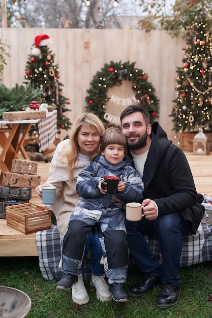 Wintervakantie en viering Kerstfamilie in de buurt van kerstboom buiten