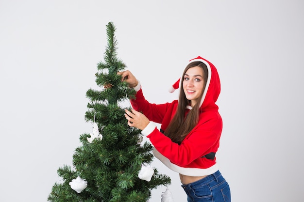Wintervakantie xmas en mensen concept gelukkige jonge vrouw gekleed in santa kostuum decoreren