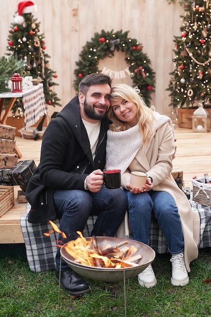 Wintervakanties en vieringen Kerstpaar verliefd in de buurt van de kerstboom buitenshuis