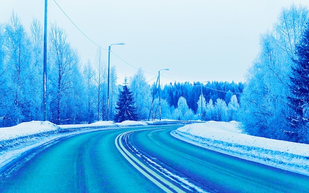 Winterweg met sneeuw in Finland. Koud landschap van Lapland. Europa bos. Finse stad snelweg rit. Rijbaan en route besneeuwde straat trip. Het rijden