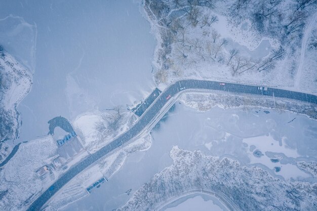 Foto winterweg rivier en sneeuwval in de stad uitzicht vanaf de hoogte van de vlucht wit-rusland koude sneeuw