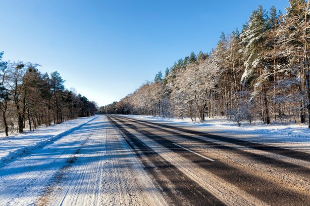 Winterweg voor autorijden in het winterseizoen, bedekt met sneeuw na sneeuwval