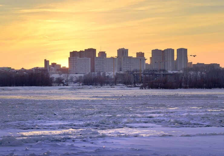 Winterzonsondergang aan de oevers van de rivier de Ob nieuwe woonwijk Gorsky aan de oever van de rivier river