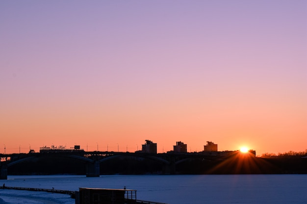 Winterzonsondergang aan de waterkant van de stad