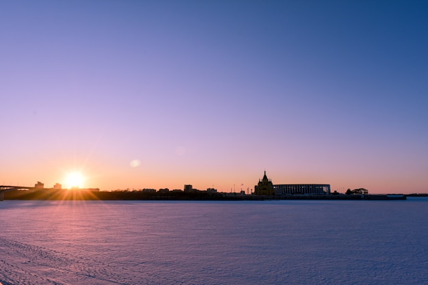 Winterzonsondergang aan de waterkant van de stad