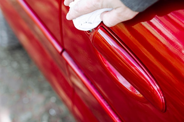 Photo wipe the car body with a rag wax polishing