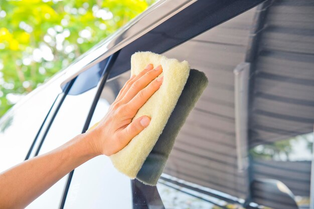 Foto pulire l'auto con un panno e la crema per lucidare la cera
