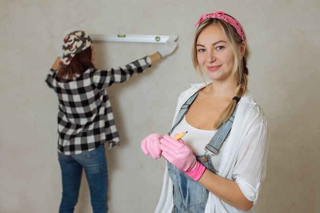 Foto pulisce due ragazze sexy con uno strumento di costruzione in mano e ripara con le proprie mani all'interno del