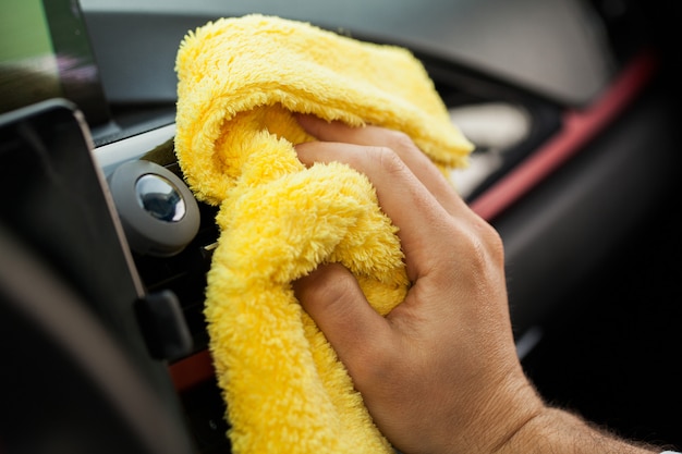 Wiping panel of a luxury car with yellow microfiber