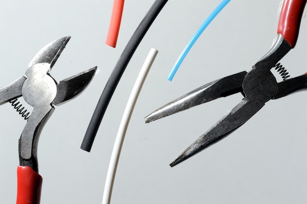 Photo wire cutters and heat shrink tubes. light background close-up.