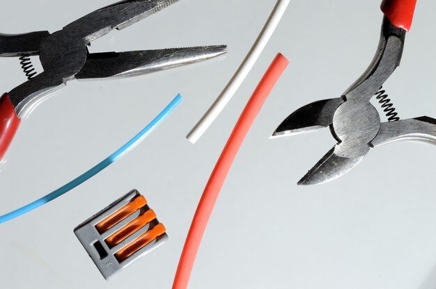 Wire cutters and heat shrink tubes. light background close-up.