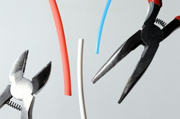 Photo wire cutters and heat shrink tubes. light background close-up.