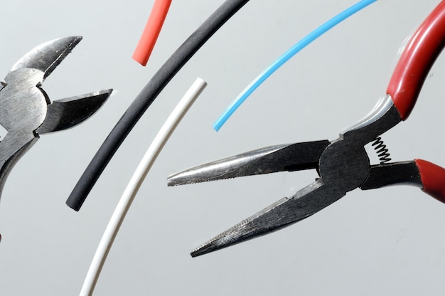 Wire cutters and heat shrink tubes. light background close-up.