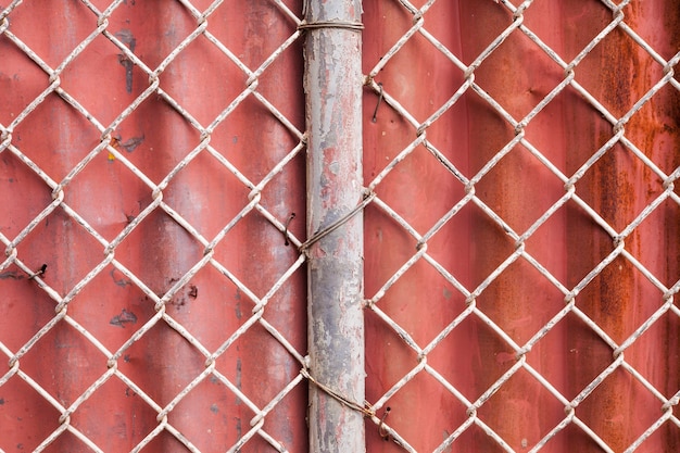 Фото Проволочная сетка и красный гофрированный забор фон