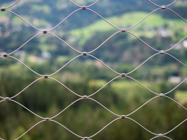 Photo wire mesh metal against landscape close up