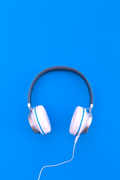 Wired headphones on blue background. Space for text.