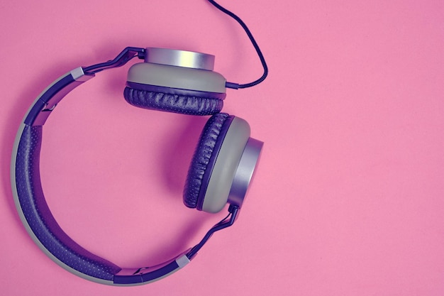 Wired headphones in khaki on a pink background.Vintage and retro.