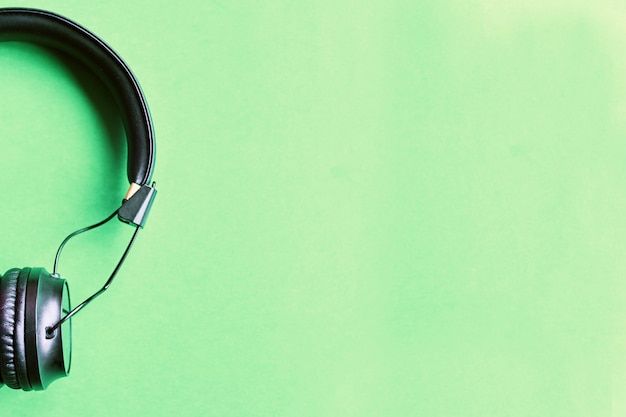 Wireless black headphones on colorful green background