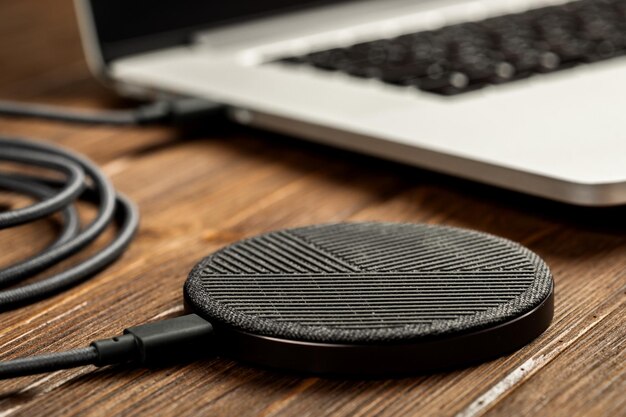 Wireless charging lies next to the computer on a stylish wooden table