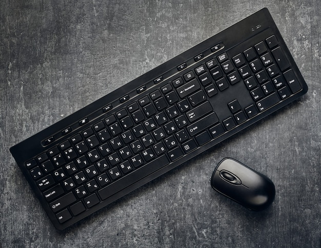 灰色の背景にワイヤレスコンピュータのキーボードとマウス