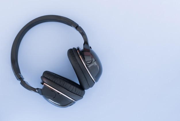 Wireless headphones are isolated on a blue background, the top view. Musical concept.