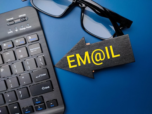 Foto tastiera wireless e occhiali con la parola email su sfondo blu