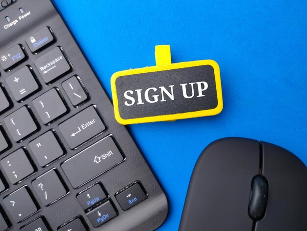 Wireless keyboard and mouse with the word sign up on blue background