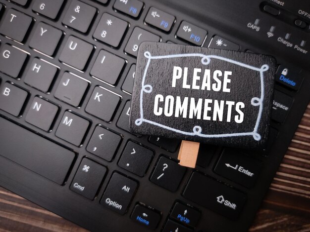 写真 木製の背景に「コメントしてください」という言葉が書かれたワイヤレスキーボード